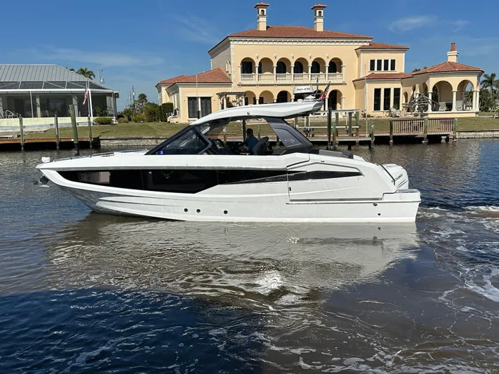  Yacht Photos Pics 2022 Galeon 325 GTO yacht cruising near luxury waterfront homes.