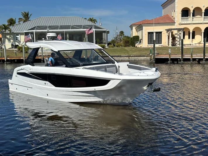  Yacht Photos Pics 2022 Galeon 325 GTO yacht cruising in a sunny waterfront neighborhood.