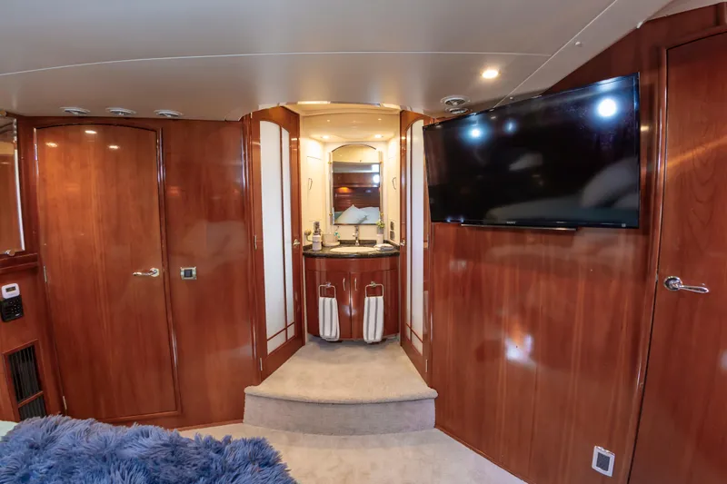 Spring Break Yacht Photos Pics Luxurious 2004 Carver Voyager interior with wood paneling, TV, and elegant bathroom.