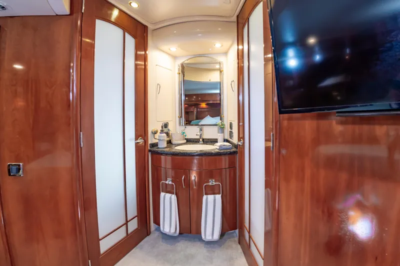 Spring Break Yacht Photos Pics Luxurious 2004 Carver Voyager bathroom with wood cabinetry, modern fixtures, and a mounted TV.