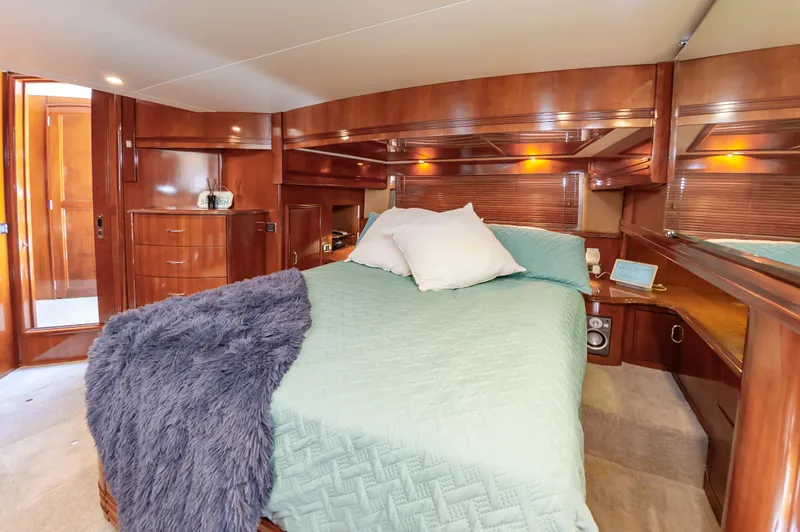 Spring Break Yacht Photos Pics Luxurious 2004 Carver Voyager bedroom with wood paneling and cozy bedding.