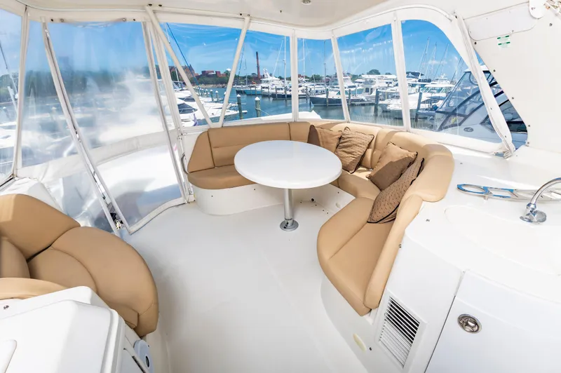 Spring Break Yacht Photos Pics 2004 Carver Voyager yacht interior with beige seating, round table, and marina view.