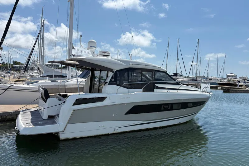  Yacht Photos Pics 2019 Jeanneau NC 33 yacht docked in a marina under a clear blue sky.