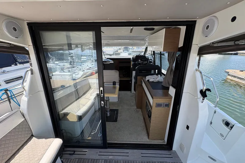  Yacht Photos Pics Interior view of 2019 Jeanneau NC 33 yacht, featuring modern seating and helm station.