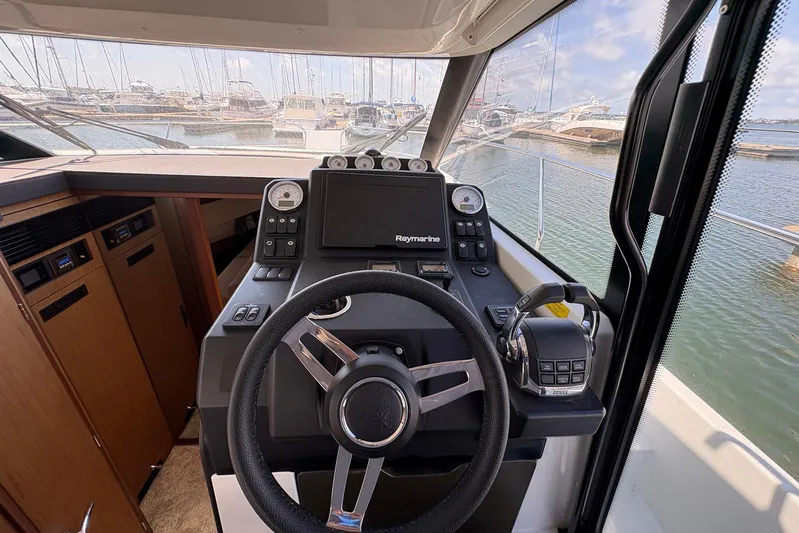  Yacht Photos Pics Cockpit view of 2019 Jeanneau NC 33 boat with steering wheel and navigation controls.