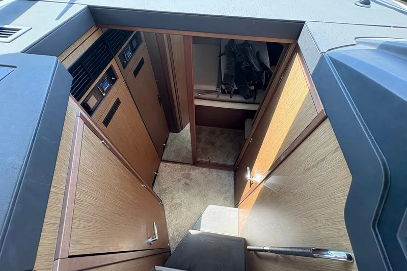  Yacht Photos Pics Interior view of 2019 Jeanneau NC 33 boat, featuring wooden cabinetry and carpeted flooring.