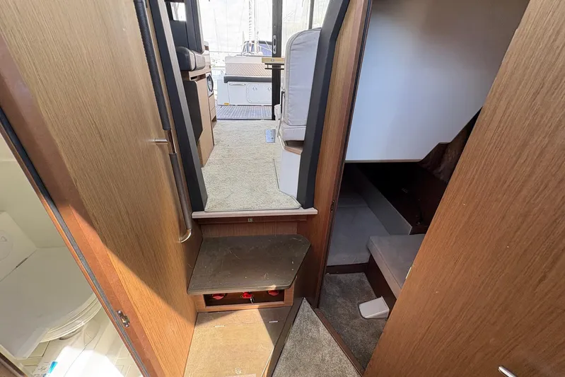  Yacht Photos Pics Interior view of 2019 Jeanneau NC 33 yacht, featuring wood paneling and carpeted steps.