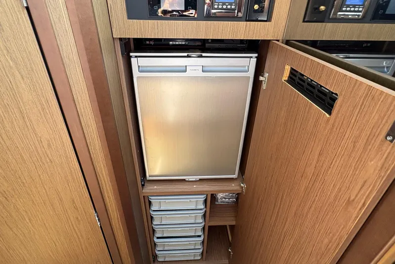  Yacht Photos Pics Compact kitchen area in 2019 Jeanneau NC 33 boat with fridge and storage drawers.