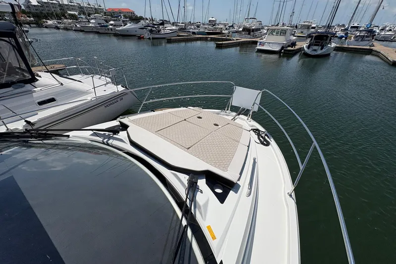  Yacht Photos Pics 2019 Jeanneau NC 33 yacht docked in a marina, surrounded by other boats.