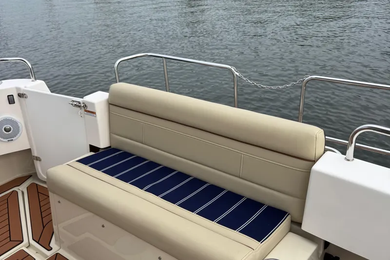  Yacht Photos Pics 2022 Ranger Tugs R-31 CB boat seating area with striped cushion, near water.