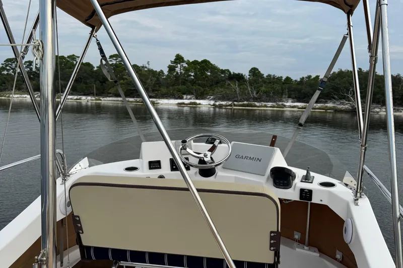  Yacht Photos Pics 2022 Ranger Tugs R-31 CB helm with Garmin navigation, overlooking serene water and shoreline.