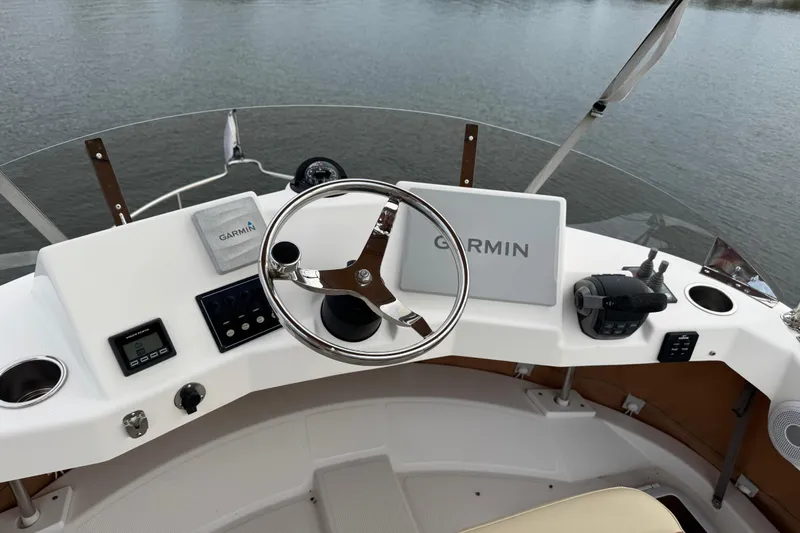 Yacht Photos Pics 2022 Ranger Tugs R-31 CB helm with Garmin navigation system on calm water.