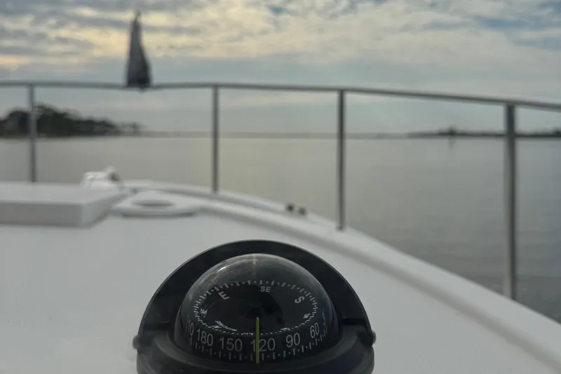 Yacht Photos Pics Compass on 2022 Ranger Tugs R-31 CB boat, overlooking calm waters and cloudy sky.