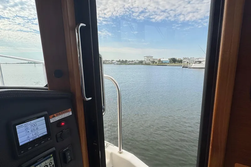  Yacht Photos Pics View from inside a 2022 Ranger Tugs R-31 CB, overlooking a serene waterfront.