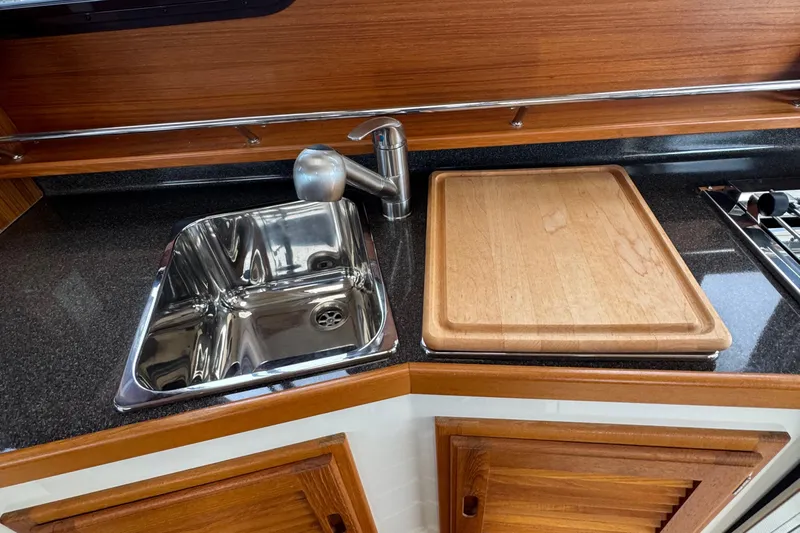  Yacht Photos Pics 2022 Ranger Tugs R-31 CB kitchen with stainless steel sink and wooden cutting board.