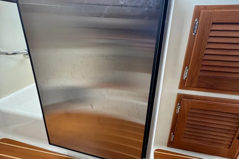  Yacht Photos Pics Interior of 2022 Ranger Tugs R-31 CB with stainless steel fridge and wooden cabinets.