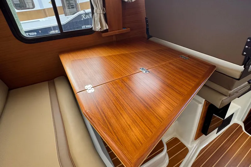 Yacht Photos Pics 2022 Ranger Tugs R-31 CB interior with wooden table and beige seating.