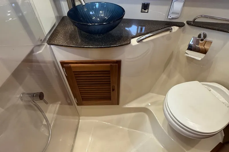  Yacht Photos Pics 2022 Ranger Tugs R-31 CB bathroom with modern sink, toilet, and wooden cabinet.