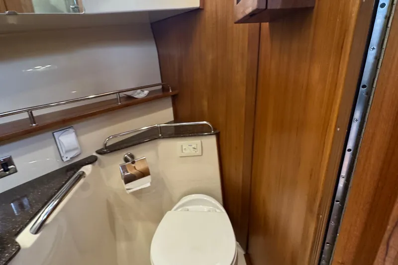  Yacht Photos Pics 2022 Ranger Tugs R-31 CB bathroom with wooden paneling and modern fixtures.