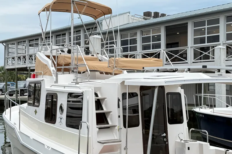  Yacht Photos Pics 2022 Ranger Tugs R-31 CB boat docked near a modern building.