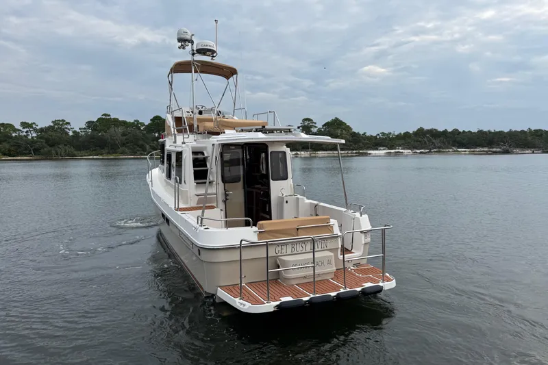  Yacht Photos Pics 2022 Ranger Tugs R-31 CB cruising on a calm lake with scenic forest backdrop.