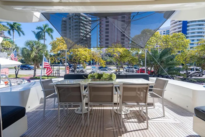 Venture Yacht Photos Pics Outdoor dining area on 2007 Arno Leopard 31 yacht, with cityscape and palm trees.