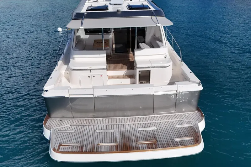  Yacht Photos Pics 2026 Riviera 505 SUV luxury yacht on clear blue water, rear view.