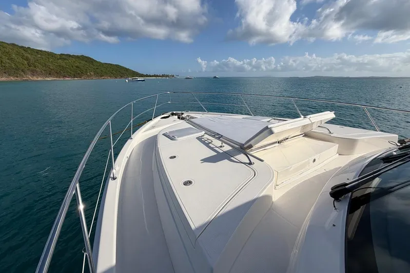  Yacht Photos Pics 2026 Riviera 505 SUV yacht cruising on serene blue waters under a partly cloudy sky.