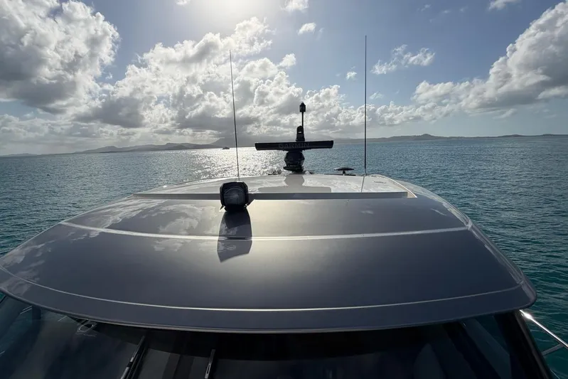  Yacht Photos Pics 2026 Riviera 505 SUV yacht cruising on a sunny day with scenic ocean view.