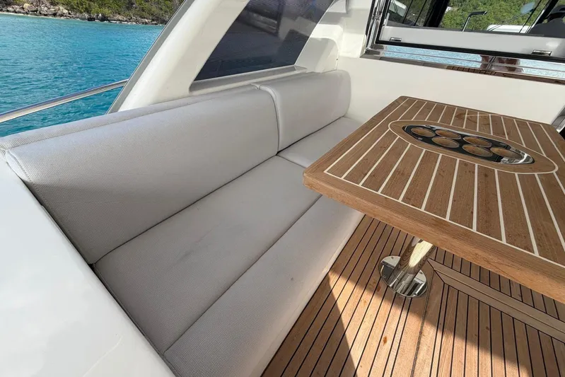  Yacht Photos Pics 2026 Riviera 505 SUV yacht interior with elegant seating and wooden table by the sea.