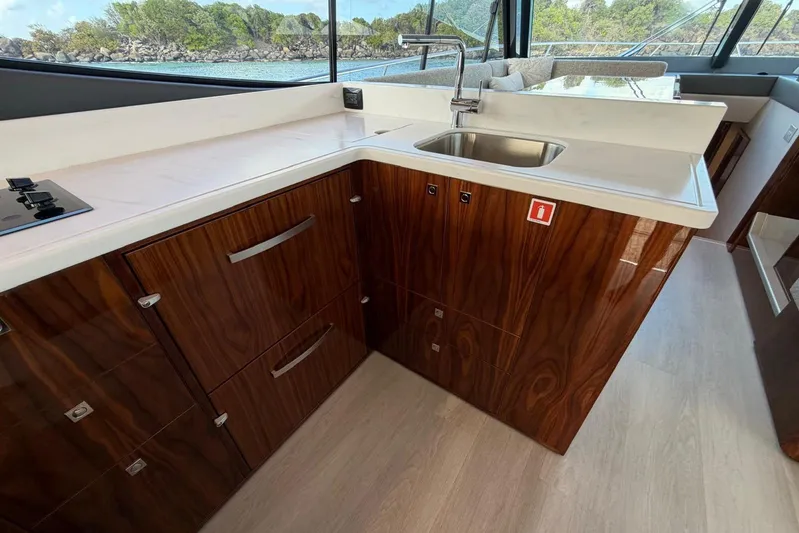  Yacht Photos Pics Luxurious kitchen area in 2026 Riviera 505 SUV yacht with wood cabinetry and modern sink.