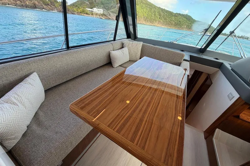  Yacht Photos Pics Luxurious interior of 2026 Riviera 505 SUV yacht with elegant wood table and scenic ocean view.
