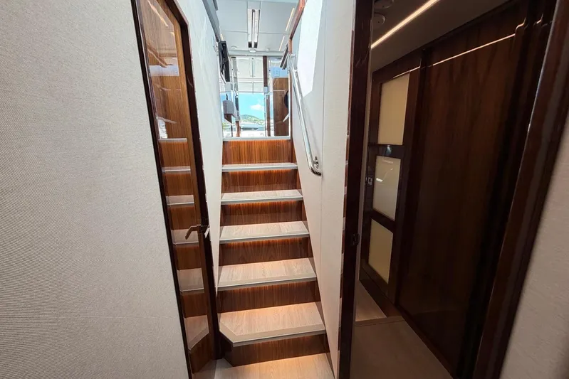  Yacht Photos Pics Interior staircase of 2026 Riviera 505 SUV yacht, featuring elegant wood finishes.