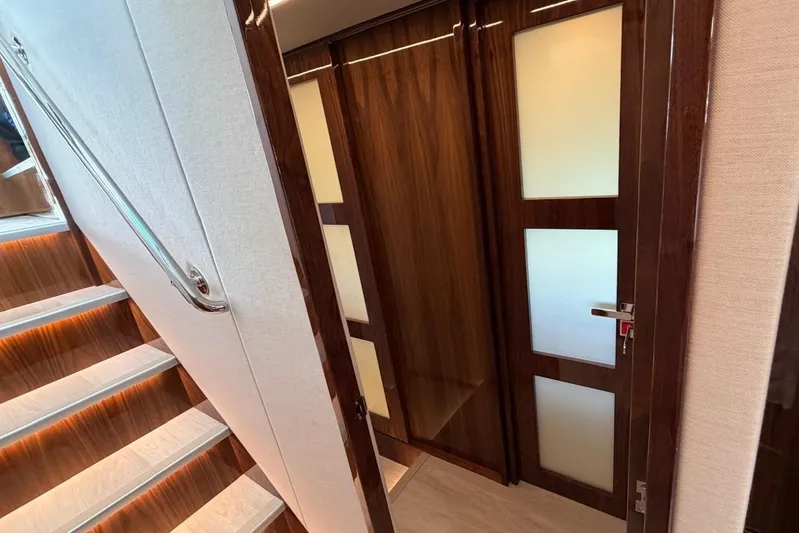  Yacht Photos Pics Interior of 2026 Riviera 505 SUV yacht with elegant wooden doors and staircase.