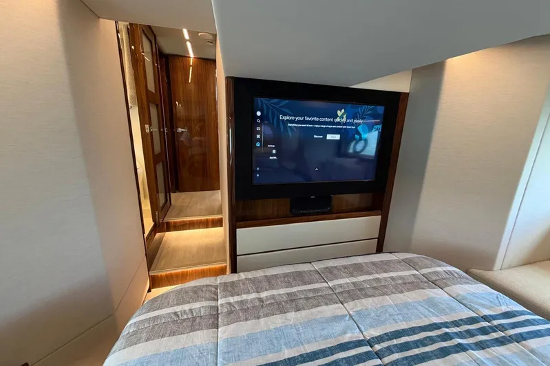  Yacht Photos Pics Luxurious interior of 2026 Riviera 505 SUV yacht with modern TV and cozy bedding.