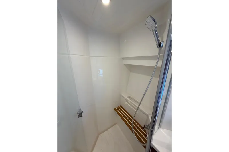 Yacht Photos Pics Shower area in 2026 Riviera 505 SUV yacht with modern fixtures and wooden bench.
