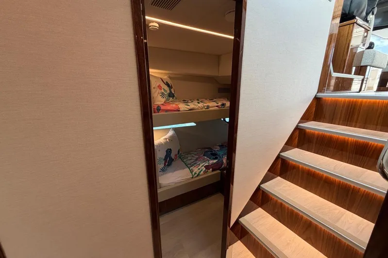  Yacht Photos Pics Interior of 2026 Riviera 505 SUV yacht with bunk beds and wooden stairs.