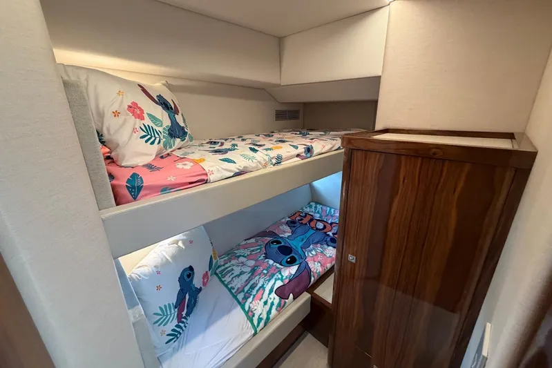  Yacht Photos Pics Bunk beds with colorful bedding in 2026 Riviera 505 SUV yacht interior.
