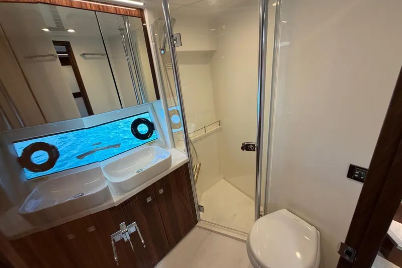  Yacht Photos Pics Luxurious bathroom in 2026 Riviera 505 SUV yacht with dual sinks and modern shower.