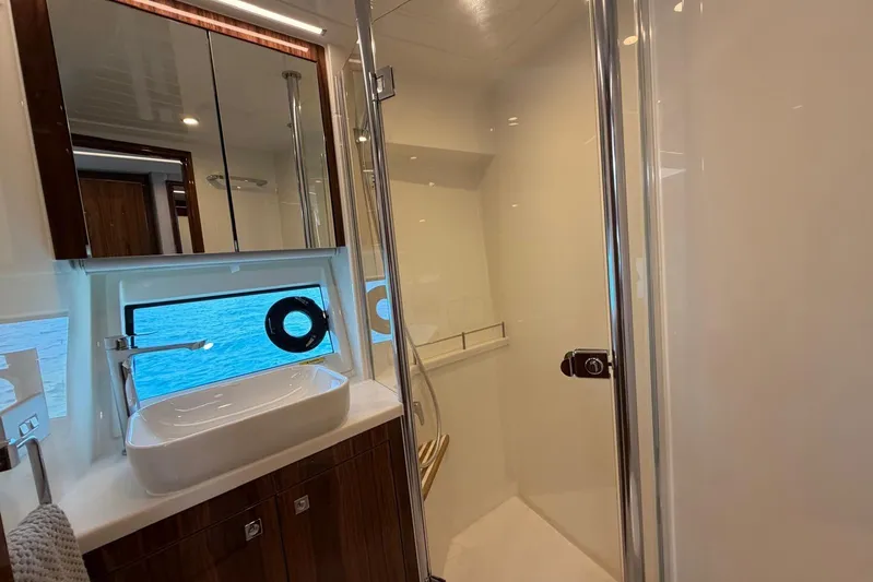  Yacht Photos Pics Luxurious bathroom in 2026 Riviera 505 SUV yacht with ocean view window.