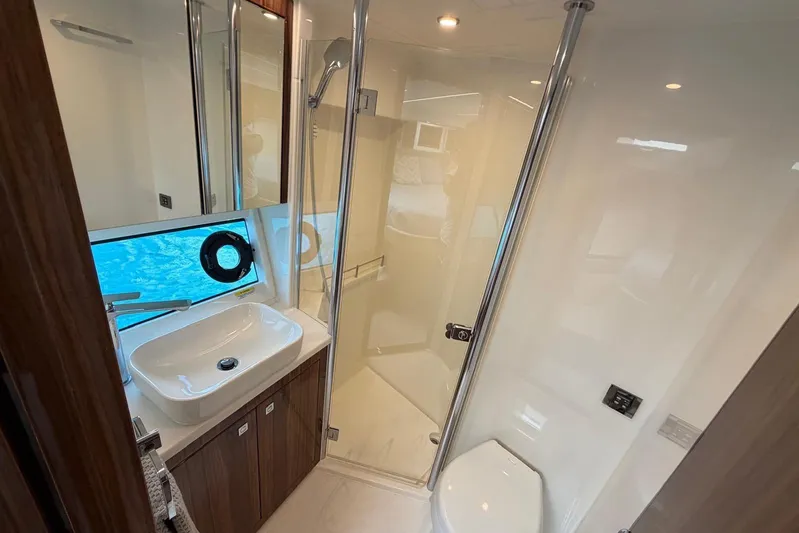 Yacht Photos Pics Luxurious bathroom in 2026 Riviera 505 SUV yacht with modern fixtures and ocean view.