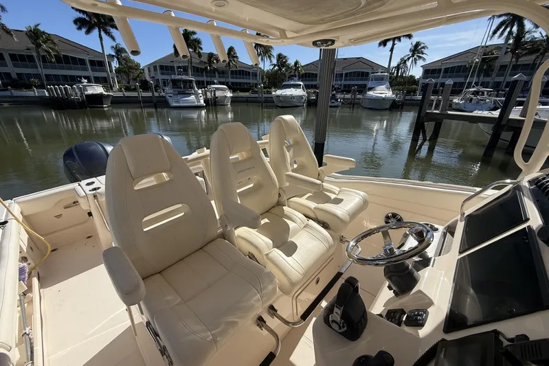  Yacht Photos Pics 2020 Grady-White Canyon 326 boat interior with helm and seating, docked near waterfront homes.