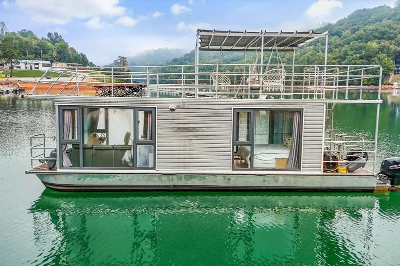  Yacht Photos Pics Modern 2024 Gospel 39 houseboat on serene lake with lush green surroundings.