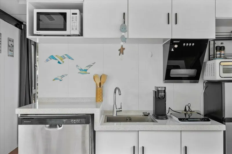  Yacht Photos Pics Modern kitchen with white cabinets, appliances, and decorative wall art. Gospel 39, 2024 model.