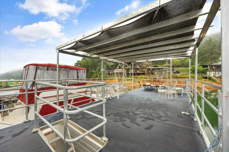  Yacht Photos Pics Rooftop deck of 2024 Gospel 39 boat with seating, overlooking serene waterfront.