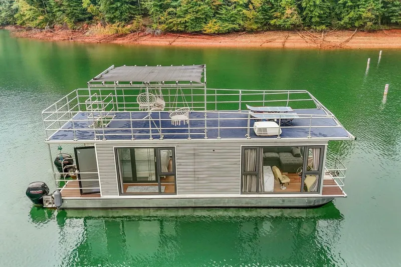  Yacht Photos Pics Houseboat on serene lake, Gospel 39 model, 2024, with rooftop seating and lush forest backdrop.
