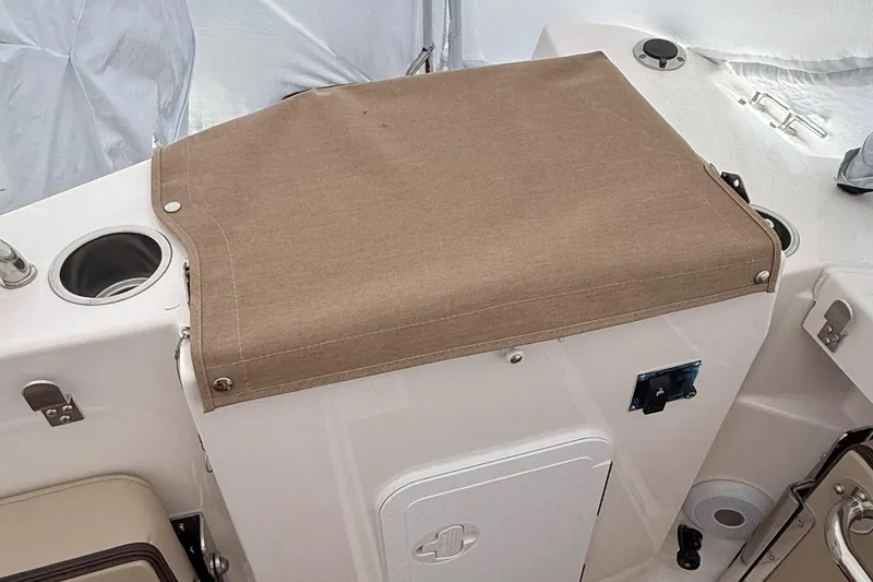  Yacht Photos Pics 2025 Ranger Tugs R-25 boat interior with covered storage compartment and cup holders.