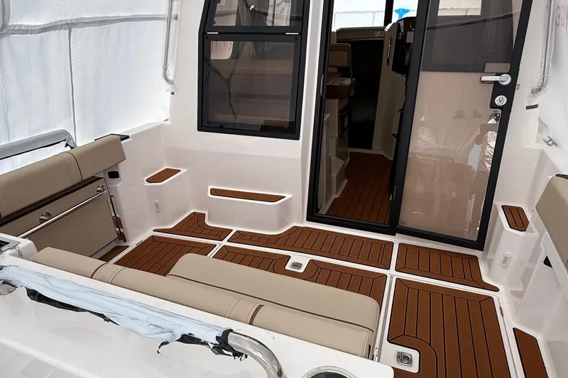  Yacht Photos Pics 2025 Ranger Tugs R-25 boat interior with teak flooring and beige seating.