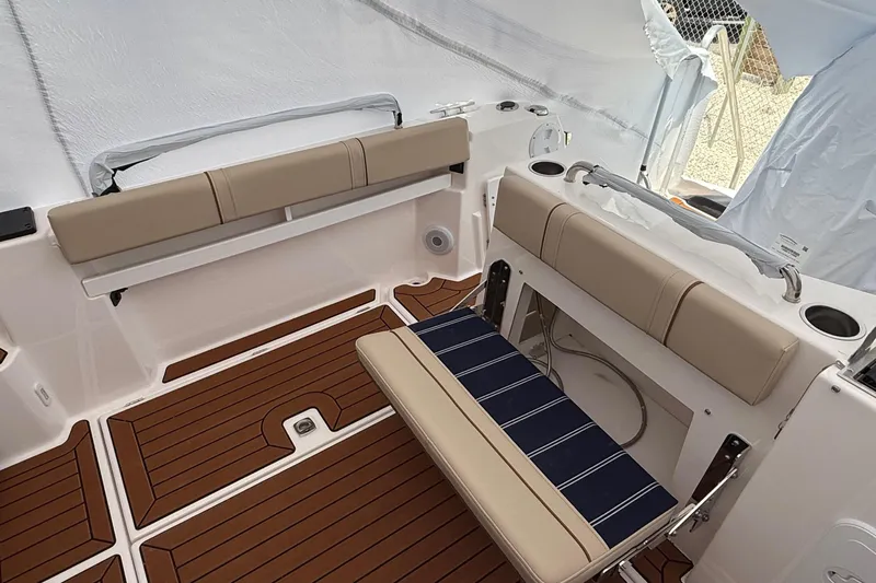  Yacht Photos Pics 2025 Ranger Tugs R-25 boat interior with cushioned seating and wood-style flooring.