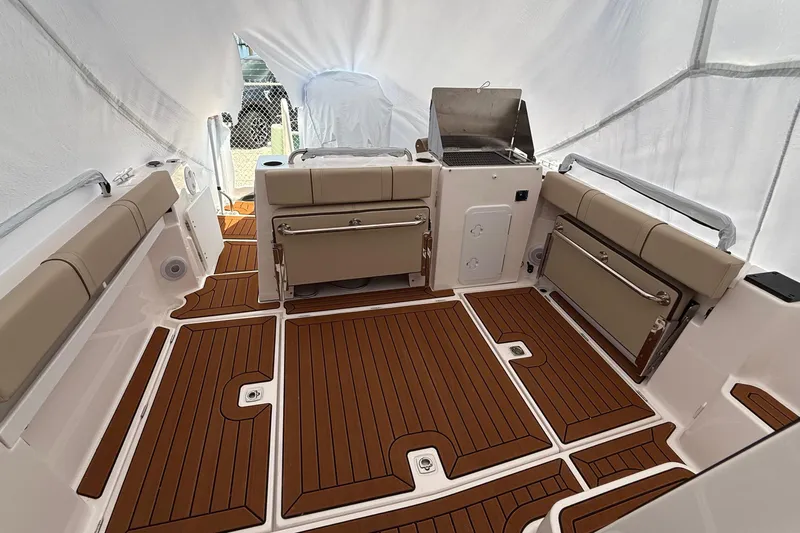  Yacht Photos Pics 2025 Ranger Tugs R-25 boat interior with teak flooring and cushioned seating.